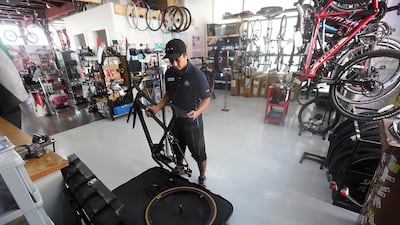 Sherman Jansen De Leon, bike technician at The Cycle Hub in Dubai, demonstrates how to pack a bike for transport using a specialised box. Satish Kumar / The National