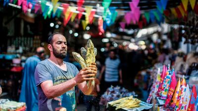 A Palestinian vendor sells salted fish at a market ahead of Eid Al Fitr in Gaza City. AFP