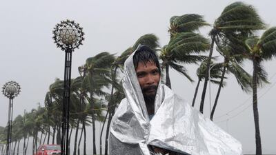 A man walks through heavy wind and rain as Typhoon Rammasun barrels across Manila on July 16, 2014, shutting down the Philippine capital on July 16. Jay Directo/AFP Photo