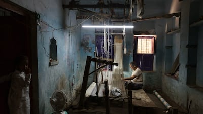 An artisan weaves a Banarasi sari in Varanasi, India. AFP