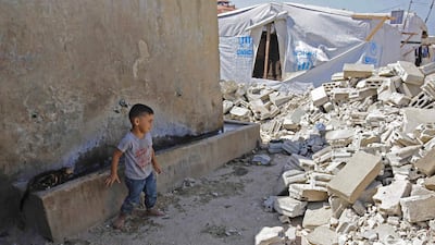A Syrian child looks at the rubble of demolished concrete walls at a make-shift camp in the town of Rihaniyye in Lebanon's Akkar governorate. AFP