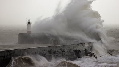Waves crash over Newhaven Lighthouse and the breakwater in Newhaven on January 2, 2024, as Storm Henk brought strong winds and heavy rain across much of southern England. (Photo by ADRIAN DENNIS / AFP)