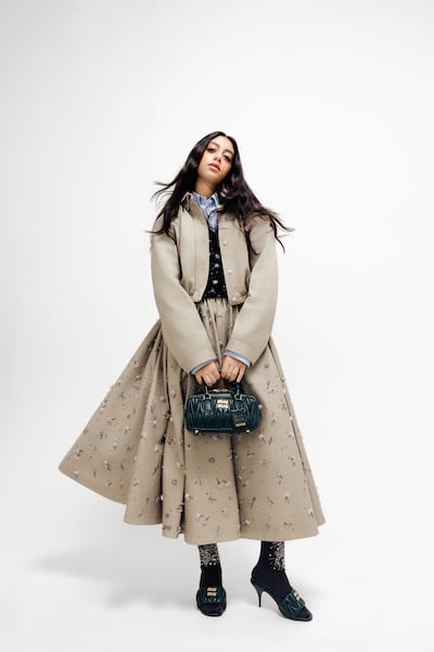 Garment-dyed cotton satin blouson jacket; embroidered cotton satin midi-skirt; poplin shirt; embroidered cashmere shirt; matelassé nappa leather mules; silk socks; and Arcadie matelassé nappa leather mini-bag, all from Miu Miu