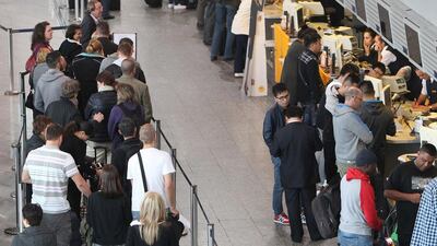 Passengers wait at counters due to a strike of pilots of German airline Lufthansa at the airport in Frankfurt. Daniel Roland / AFP