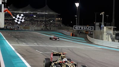 Lotus F1 Formula One driver Kimi Raikkonen of Finland takes the chequered flag to win the Abu Dhabi F1 Grand Prix at the Yas Marina circuit on Yas Island November 4, 2012. REUTERS/Darren Whiteside (UNITED ARAB EMIRATES - Tags: SPORT MOTORSPORT F1) *** Local Caption *** PSQ129_MOTOR-RACING_1104_11.JPG