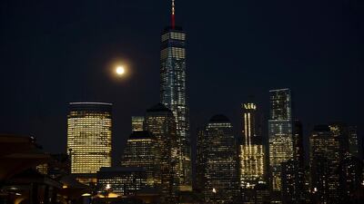 The full moon rises behind One World Trade Center in New York, its mast displaying the colors of the Belgian flag in a show of support following the terrorist attacks in Brussels. Trevor Collens / AFP