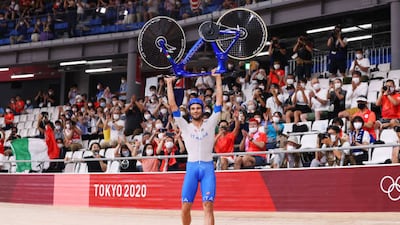 Filippo Ganna of Team Italy lifts his bike to celebrate winning a gold medal after setting a new world record during the men's team pursuit finals.