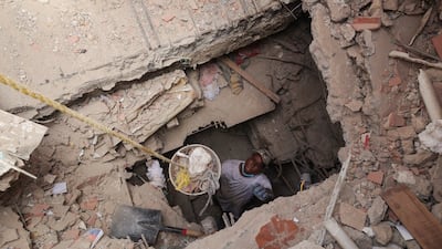 A man looks for his grandmother and uncle after digging a tunnel trying to get to the first floor of where his grandmother lived, in the aftermath of the June 24 earthquakes in La Guaira, Venezuela. Reuters