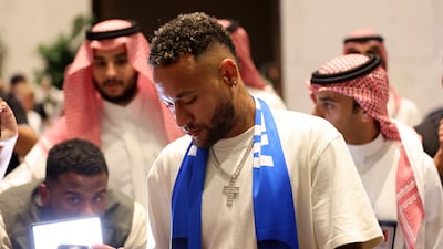 Al Hilal's new signing Neymar signs autographs upon arrival in Riyadh. Reuters