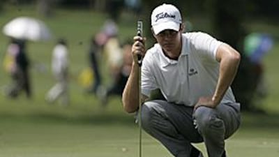 Adam Blyth eyes up a putt on the fourth green during the third round of the Malaysian Open.