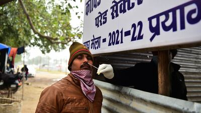 A health worker takes a swab sample from a policeman at a coronavirus testing station before the Magh Mela festival in Allahabad, Uttar Pradesh, India. AFP