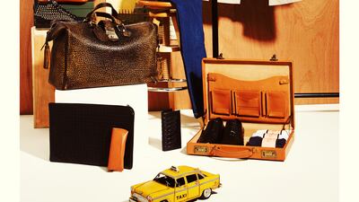 Menswear - Travel: Styled by Katie Trotter and Nadia El Dasher; Photograph by Tina Chang Trench, Burberry Brit. Scarf, Alexander McQueen. Jeans, Nudie Jeans; hat, Block Headwear, both at Bloomingdale's. New York subway map, Actua; Statue of Liberty poster, Cavallani & Co., both at Bloomingdale's Home. Bag, Gucci. Cushion, FS Home Collections at Bloomingdale's Home. Zipper bag, Jack Spade; trainers, Giocomorelli, both at Bloomingdale's. Laptop case, Bottega Veneta. Eyeglass case, Hartmann at Bloomingdale's Home. Yellow taxi, Hans Helmut at Bloomingdale's Home. Wallet; shoes, Dh3,000, both Alexander McQueen. Boxer shorts, Thomas Pink. Briefcase, Hartmann at Bloomingdale's Home.