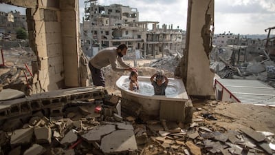 Salem Saoody, 30, is getting his daughter Layan (l) and his niece Shaymaa 5 (r) in the only remaining piece from their damaged house, which is the bathing tub. They now live in a caravan near the ruins. Wissam Nassar