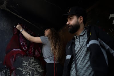 A demonstrator draws graffiti on a wall of The Egg. Reuters