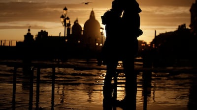 A couple stand in a golden sunset in Venice, Italy, just hours after an exceptional 1.5 meter tide receded from nearby St Mark's Square. AP