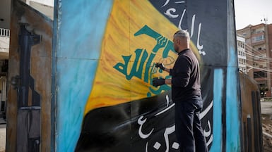 A man paints the Hezbollah flag on a board in Tyre, south Lebanon. Reuters