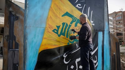 A man paints the Hezbollah flag on a board in Tyre, south Lebanon. Reuters