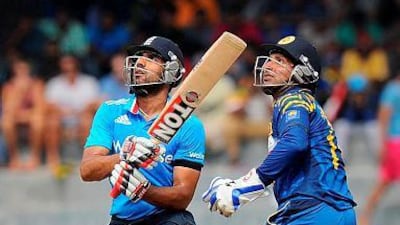 England cricketer Ravi Bopara, left, is watched by Sri Lankan wicketkeeper Kumar Sangakkara as he plays a shot during the second One Day International (ODI) match between Sri Lanka and England at the R. Premadasa Cricket Stadium in Colombo on November 29, 2014. AFP PHOTO/ Ishara S. KODIKARA