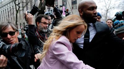 Adult-film actress Stormy Daniels is ushered through the media scrum outside a New York court on her way into Michael Cohen's hearing. AP