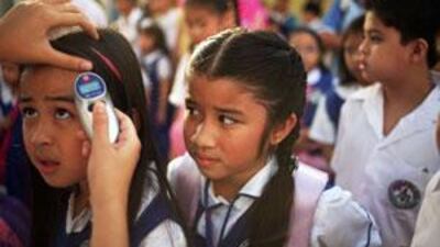 A nurse at Abu Dhabi's Philippine National School, checks pupils' temperature before they enter the classroom yesterday.