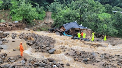 This handout photo taken and released on July 15, 2023 by the Gyeongbuk Fire Service Headquarters shows South Korean emergency workers searching for survivors at a house destroyed by flood waters after heavy rains in Yecheon. Seven people have died and three have gone missing amid torrential rains that have flooded many parts of South Korea, forcing thousands of people to evacuate from homes amid the warning of an overflowing dam. (Photo by Handout / Gyeongbuk Fire Service Headquarters / AFP) / RESTRICTED TO EDITORIAL USE - MANDATORY CREDIT "AFP PHOTO / Gyeongbuk Fire Service Headquarters" - NO MARKETING NO ADVERTISING CAMPAIGNS - DISTRIBUTED AS A SERVICE TO CLIENTS