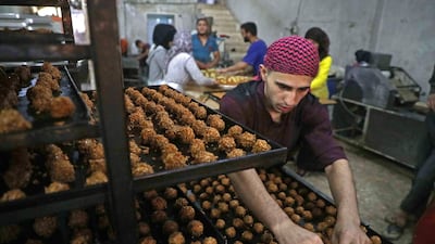 Traditional sweets being prepared at a bakery run by displaced Syrians in the town of Dana, east of the Turkish-Syrian border in the northwestern Idlib province. Aaref Watad / AFP