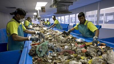Workers sift through the rubbish from the Sharjah landfill to separate the recyclables. Jeff Topping / The National