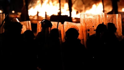 Riot policemen watch flames rise from the tents of anti-government protesters in Beirut. AP Photo