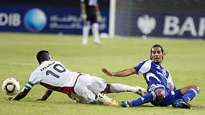 Al Jazira's Diaky Ibrahim, left, and Al Nasr's Humaid Abulla Abbas collide.