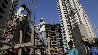 Indian labourers work at a new building under construction in Mumbai. Divyakant Solanki / EPA