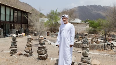 Abdullah Al Saadi in front of one of his rock installations outside his studio. Reem Mohammed / The National