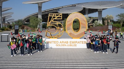 Children posing for a group photo in front of the UAE's Golden Jubilee installation at the Earth Plaza. Image: Expo 2020 Dubai