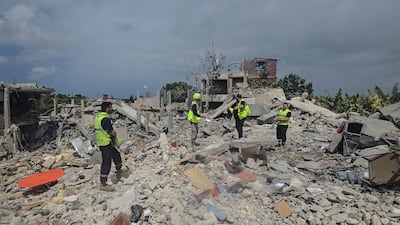 Civil defence members search for victims in the rubble in Burj Al Shamali. AFP