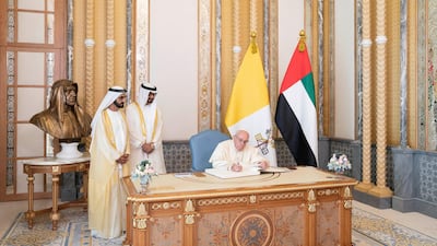 Pope Francis signs a guest book during an official reception at the Presidential Palace on February 4, 2019. He is with Sheikh Mohammed bin Rashid (left), and Sheikh Mohamed bin Zayed (second left). Ryan Carter / Ministry of Presidential Affairs