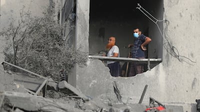Palestinian men work at the site of an Israeli air strike on a house in Gaza City on October 16. Reuters