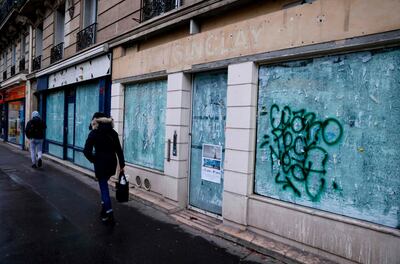 Pedestrians walk past closed shops in Paris. France recorded the largest decrease in overall retail trade of 18 per cent in November. AFP