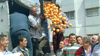 Lebanese farmers dump oranges and lemons in Sidon's main square during a protest against a growth in the number of agricultural products, notably citrus fruits, that are illegally entering the country from Syria on May 2, 2000. AFP