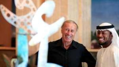 Josef Hickersberger, left, the head coach of Al-Wahda football club, and Ismael Matar, a UAE player, stand near a sculpture during a promotional event for the Royal Euro 2008 Football Charity in Abu Dhabi.