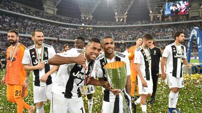 Juventus players carry around the Italian Super Cup on a lap of honour. EPA