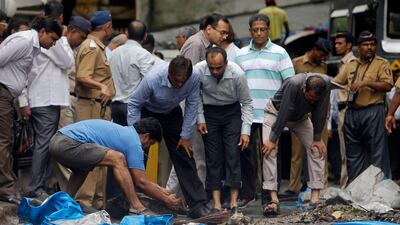 July 15 2011: A man moves debris during a clean-up operation near the Opera House, one of the sites of the triple explosions, in Mumbai July 15, 2011. Vivek Prakash / Reuters