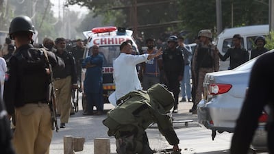 A bomb disposal squad checks a bag belonging to an attacker outside the Chinese consulate in Karachi. AFP