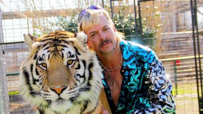 Joseph Maldonado-Passage, also known as Joe Exotic, poses with one of his tigers. AFP / Netflix