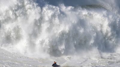 A jet ski steers away from a crashing wave during a big wave surfing session at Praia do Norte, or North Beach, in Nazare, Portugal. AP Photo