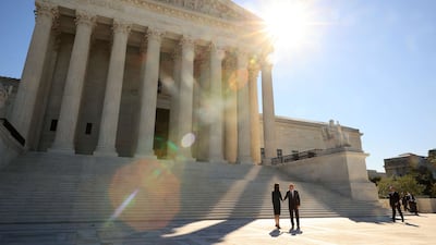 US Supreme Court Associate Justice Amy Coney Barrett (left) with Chief Justice John Roberts in front of the Supreme Court, following her investiture ceremony on October 01, 2021 in Washington. Ms Barrett has been a member of the court for more than a year but the ceremony was delayed due to the pandemic. Getty / AFP