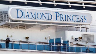 A passenger wearing a mask stands on the deck of the cruise ship Diamond Princess. Reuters