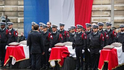French President Emmanuel Macron stands by coffins during a ceremony to pay tribute to the victims of the 03 October knife attack in Paris' Police headquarters. EPA