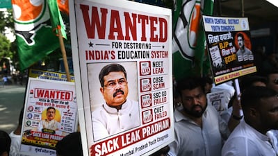 Protesters hold signs demanding the removal of Dharmendra Pradhan as education minister. AFP
