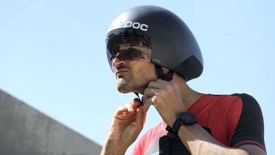 Sebastian Jensen secures his helmet before training on his bike. Chris Whiteoak / The National