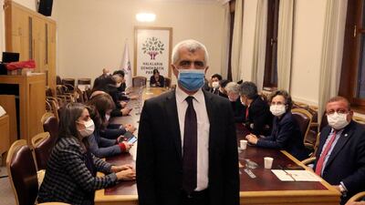Omer Faruk Gergerlioglu, a human rights advocate and lawmaker from the People's Democratic Party (HDP) stands in front with his colleagues sitting in support, after the parliament stripped his parliamentary seat, in Ankara, Turkey. AP