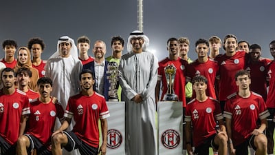 Dr Sultan Al Jaber, centre, alongside players and staff of the Al Jazira Football Academy. Antonie Robertson / The National